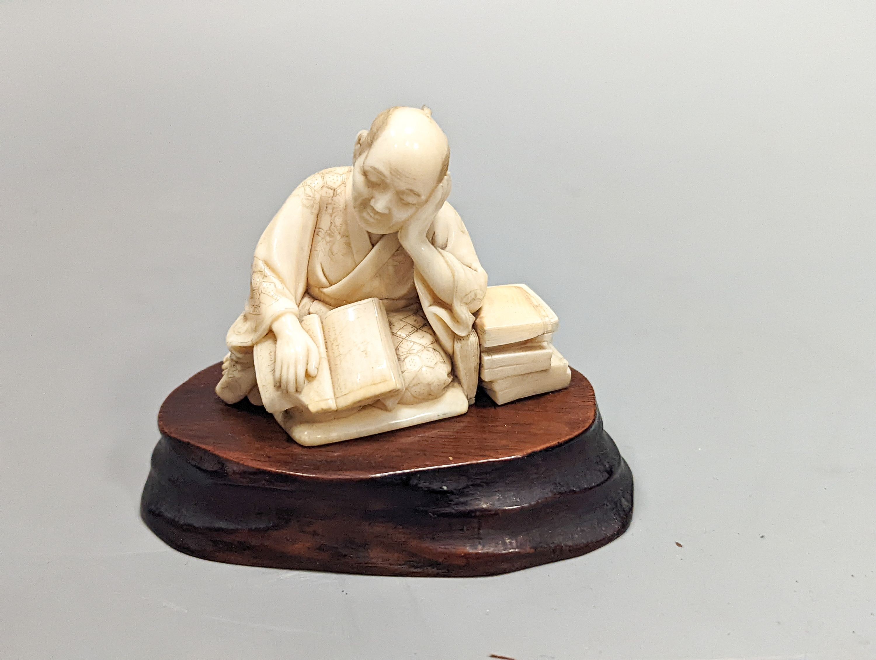 A Japanese ivory okimono of a scholar, Meiji period, signed, 5 cms high not including stand.